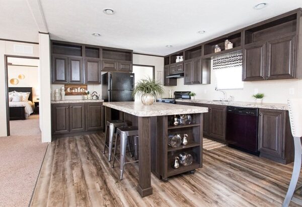 Modern kitchen with dark wood cabinets, marble countertops, center island with shelves, stainless steel appliances, and a view into a bedroom.