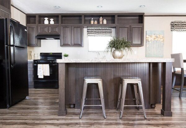 Modern kitchen with dark wood cabinets, a black fridge and stove, a marble island countertop, two metal bar stools, and wood flooring.
